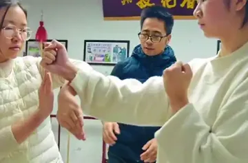 Master Liu teaching Wing Chun techniques to two young women in a training session.